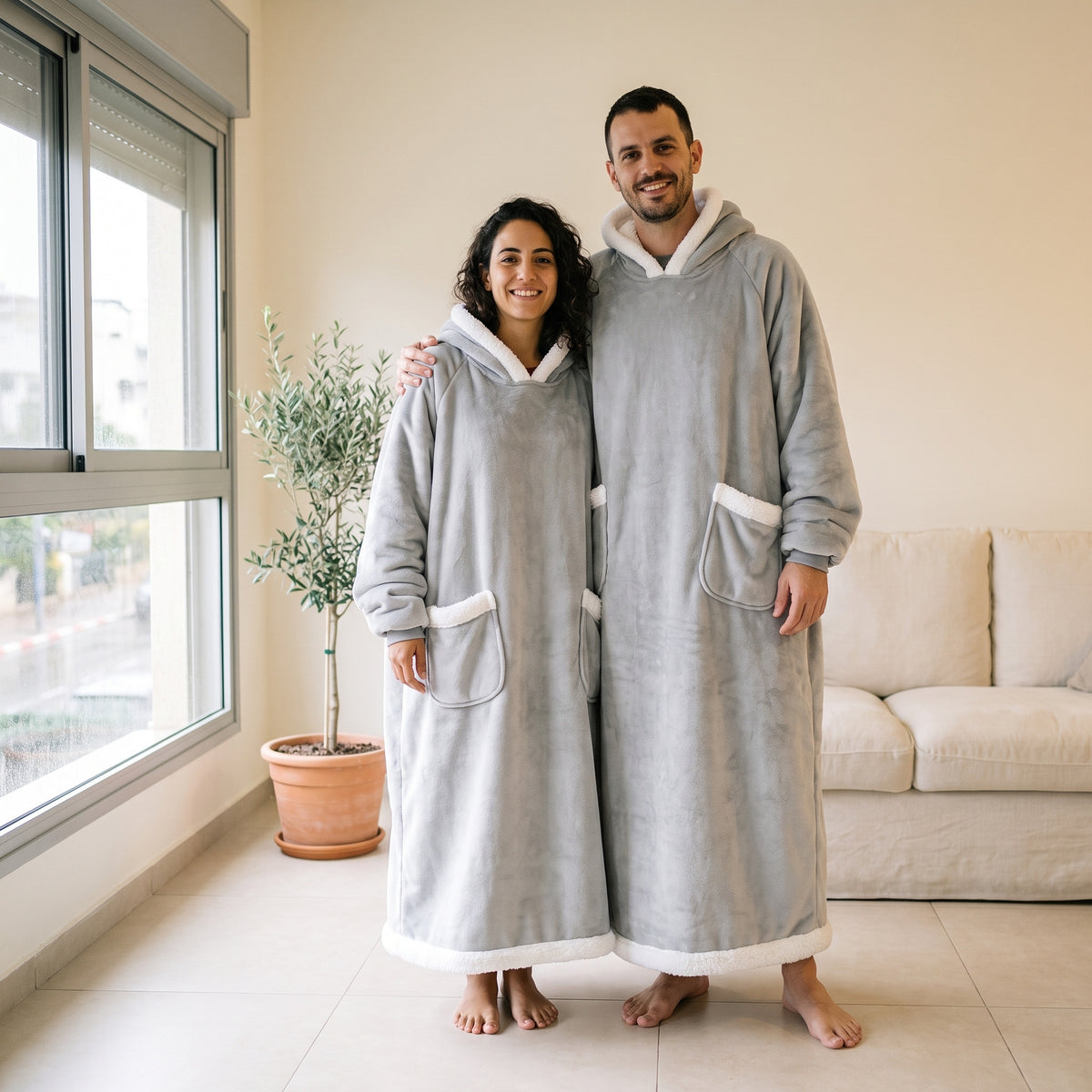 גבר ואישה עומדים בסלון בקפוצ'ון שמיכה אפור באורך מלא, עם שני כיסים קדמיים